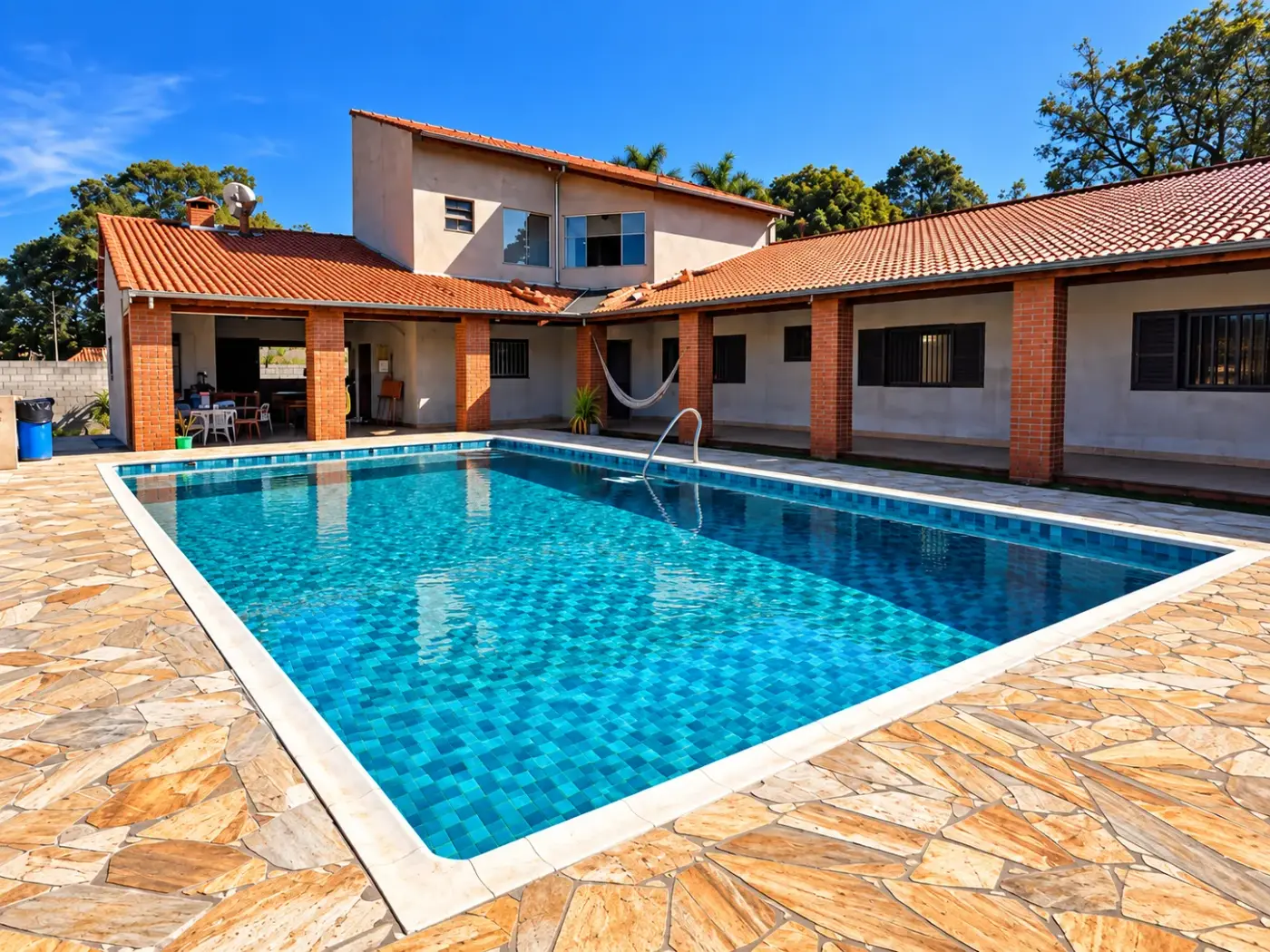 Piscina de vinil azul recém-construída, com deck de pedra e casa ao fundo