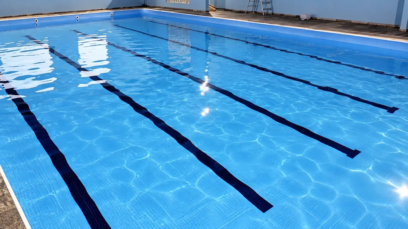 Piscina semi-olímpica de academia com vinil azul novo e raias pretas no fundo, depois da troca feita pela Marks em São Bernardo do Campo