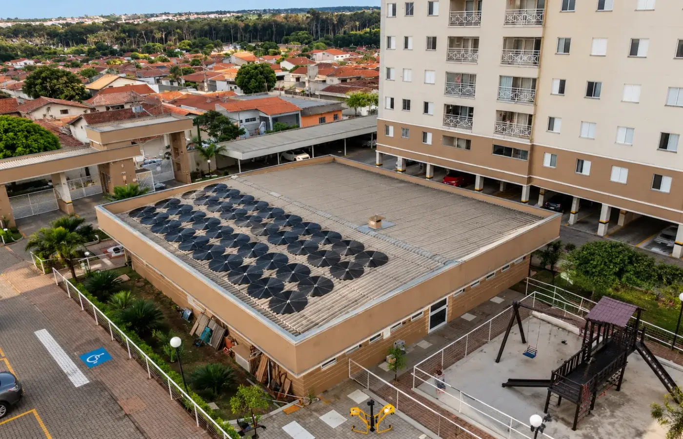 Vista do alto de um condomínio com coletores solares de piscina instalados sobre a cobertura