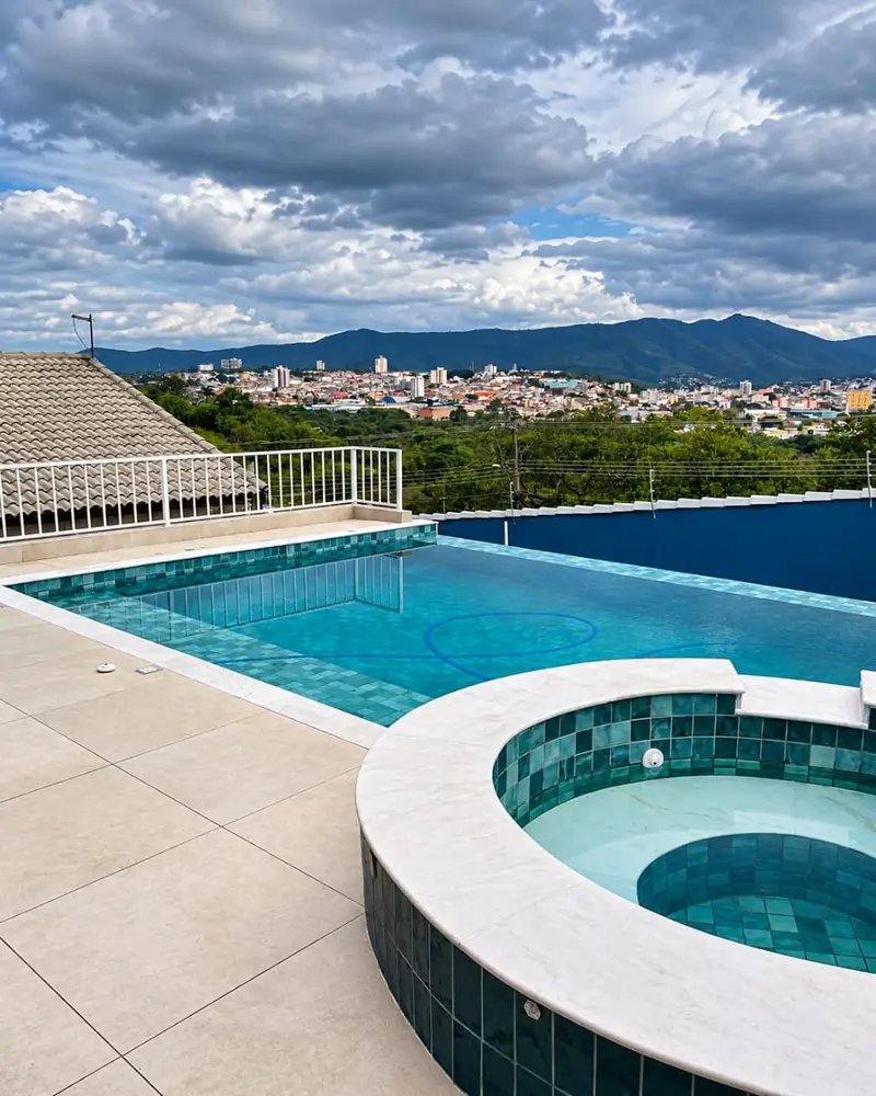 Piscina com spa redondo elevado e vista para a cidade de Atibaia e as montanhas