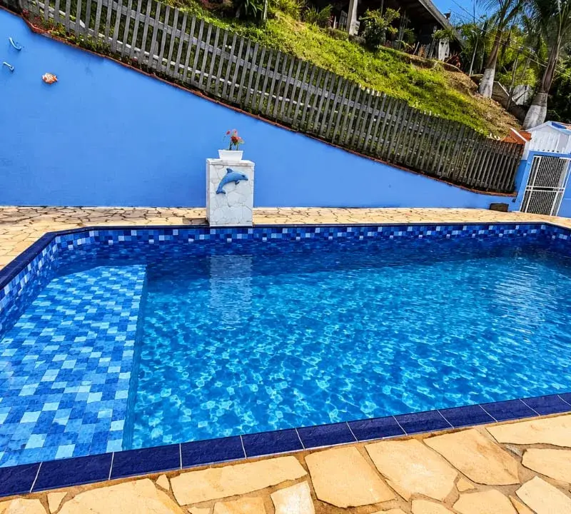Piscina de vinil retangular com estampa de pastilha azul e deck de pedra, depois da troca de vinil, em Atibaia
