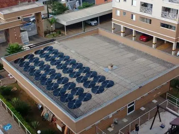 Vista do alto de um condomínio de prédios com coletores solares de piscina sobre a cobertura do salão