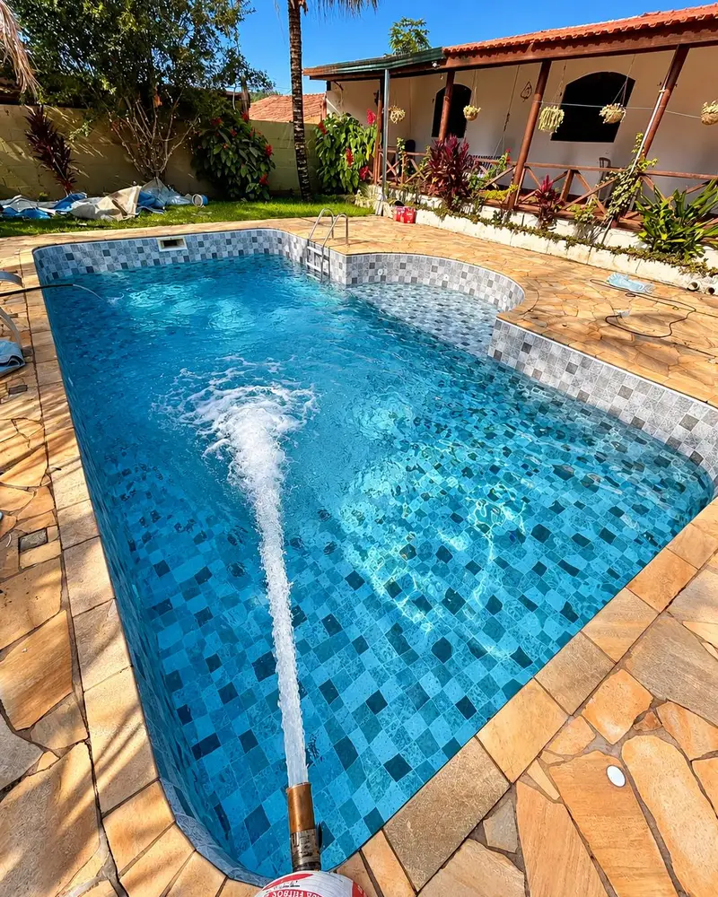 Piscina com vinil novo estampado sendo enchida